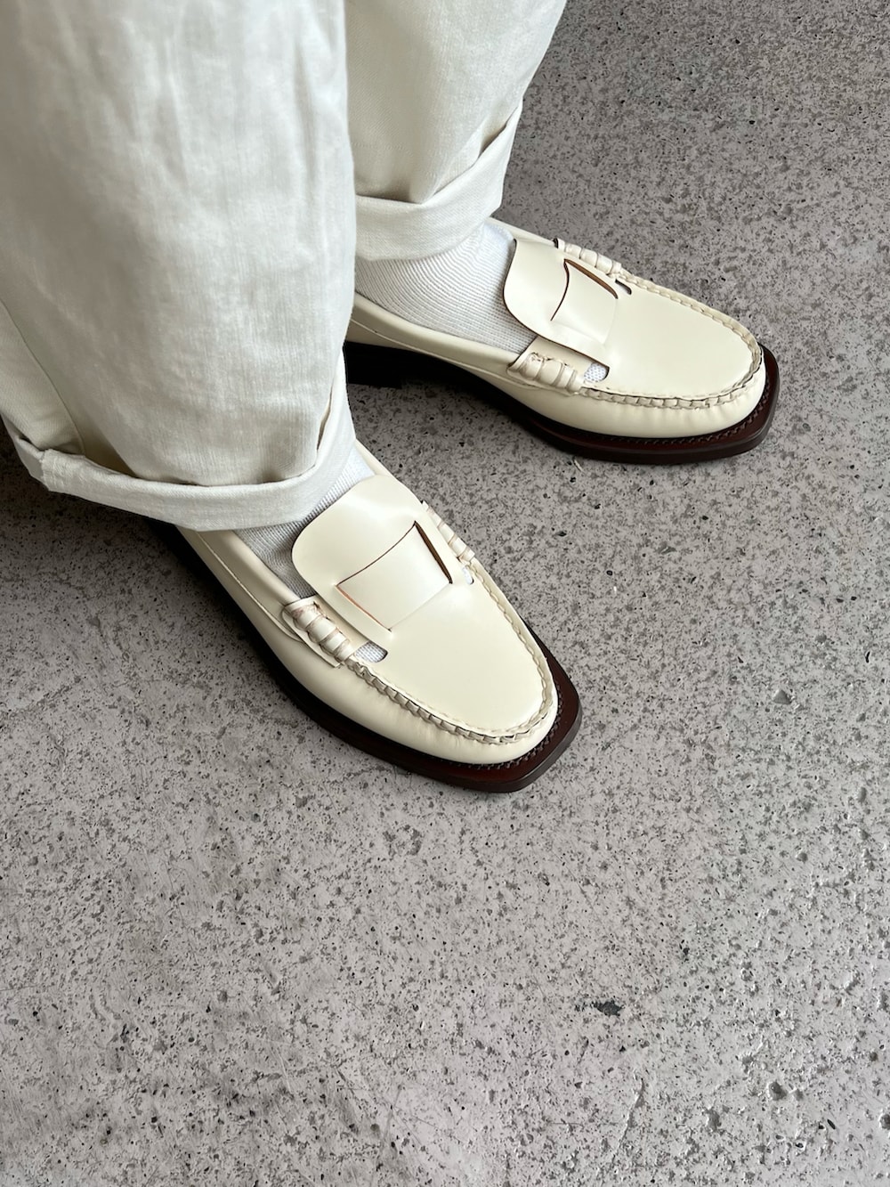 レッド系のニット/セーター、ホワイト系のその他パンツ、ベージュ系のローファーを着用したレディースの秋コーディネートの3枚目の写真