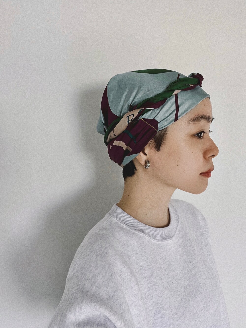 グレー系のスウェット、ブラック系のスニーカー、パープル系のバンダナ/スカーフを着用したレディースの秋コーディネートの3枚目の写真