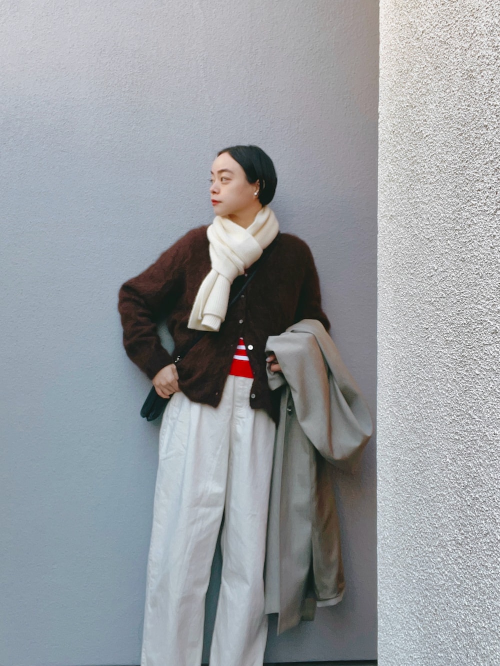 ブラウン系のカーディガン/ボレロ、レッド系のトップス、ホワイト系のその他パンツを着用したレディースの冬コーディネートの2枚目の写真