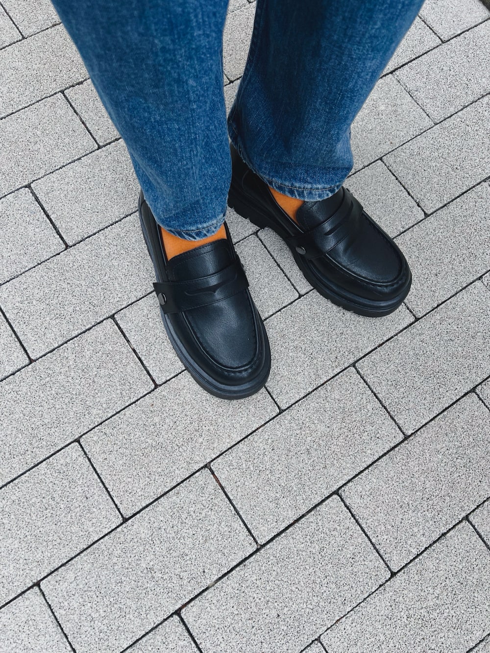 ブルー系のトップス、ブルー系のデニムパンツ、ブラック系のパンプスを着用したレディースの秋コーディネートの4枚目の写真