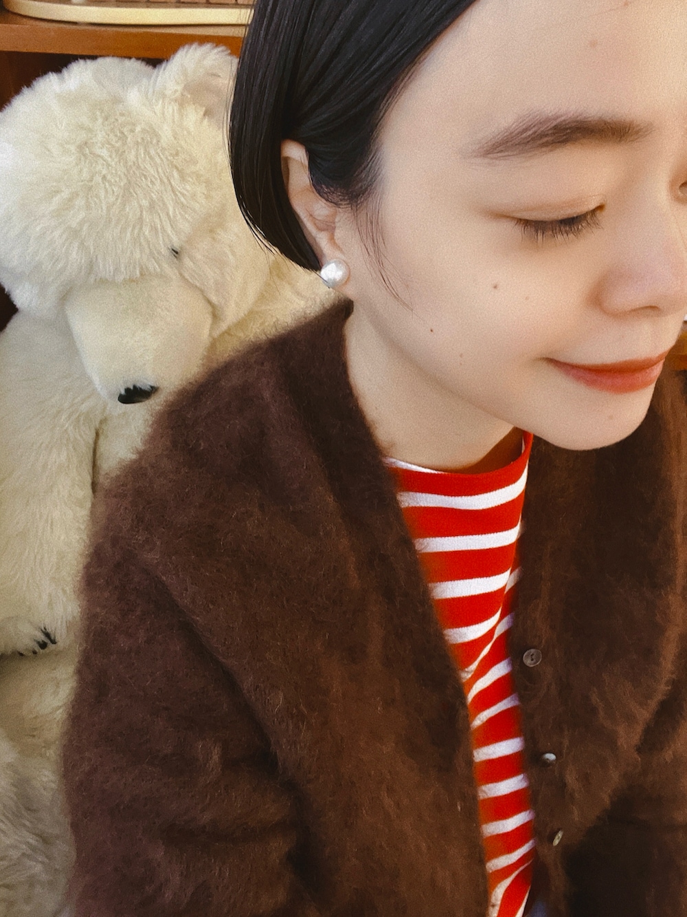 ブラウン系のカーディガン/ボレロ、レッド系のトップス、ホワイト系のその他パンツを着用したレディースの冬コーディネートの3枚目の写真