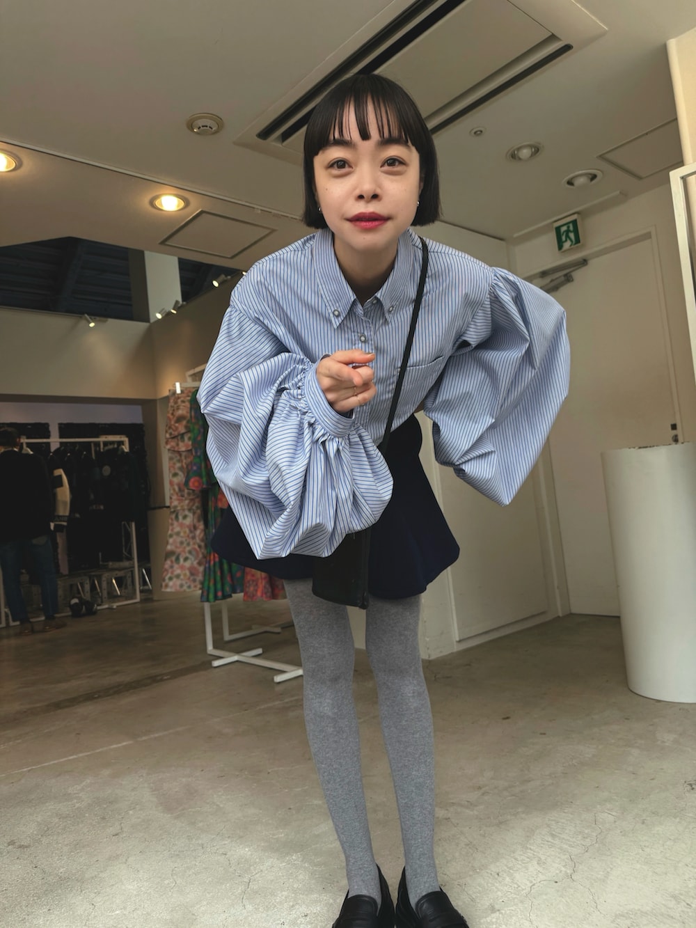 ブルー系のシャツ/ブラウス、ブルー系のパンツ、ブラック系のパンプスを着用したレディースの春コーディネートの2枚目の写真