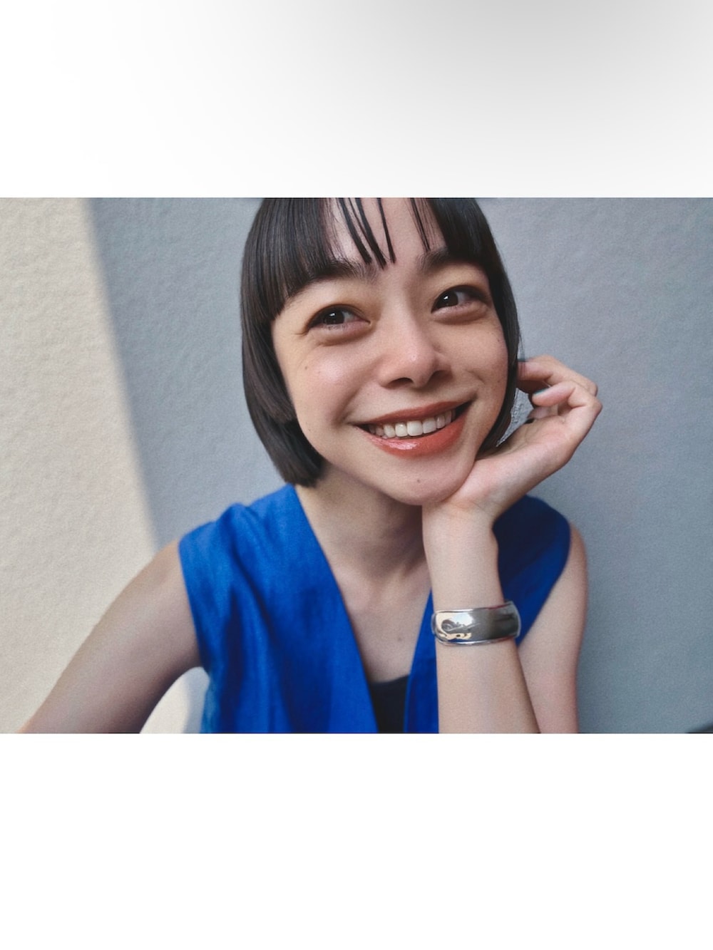 ブルー系のワンピース、シルバー系のサンダル、シルバー系のブレスレットを着用したレディースの夏コーディネートの2枚目の写真