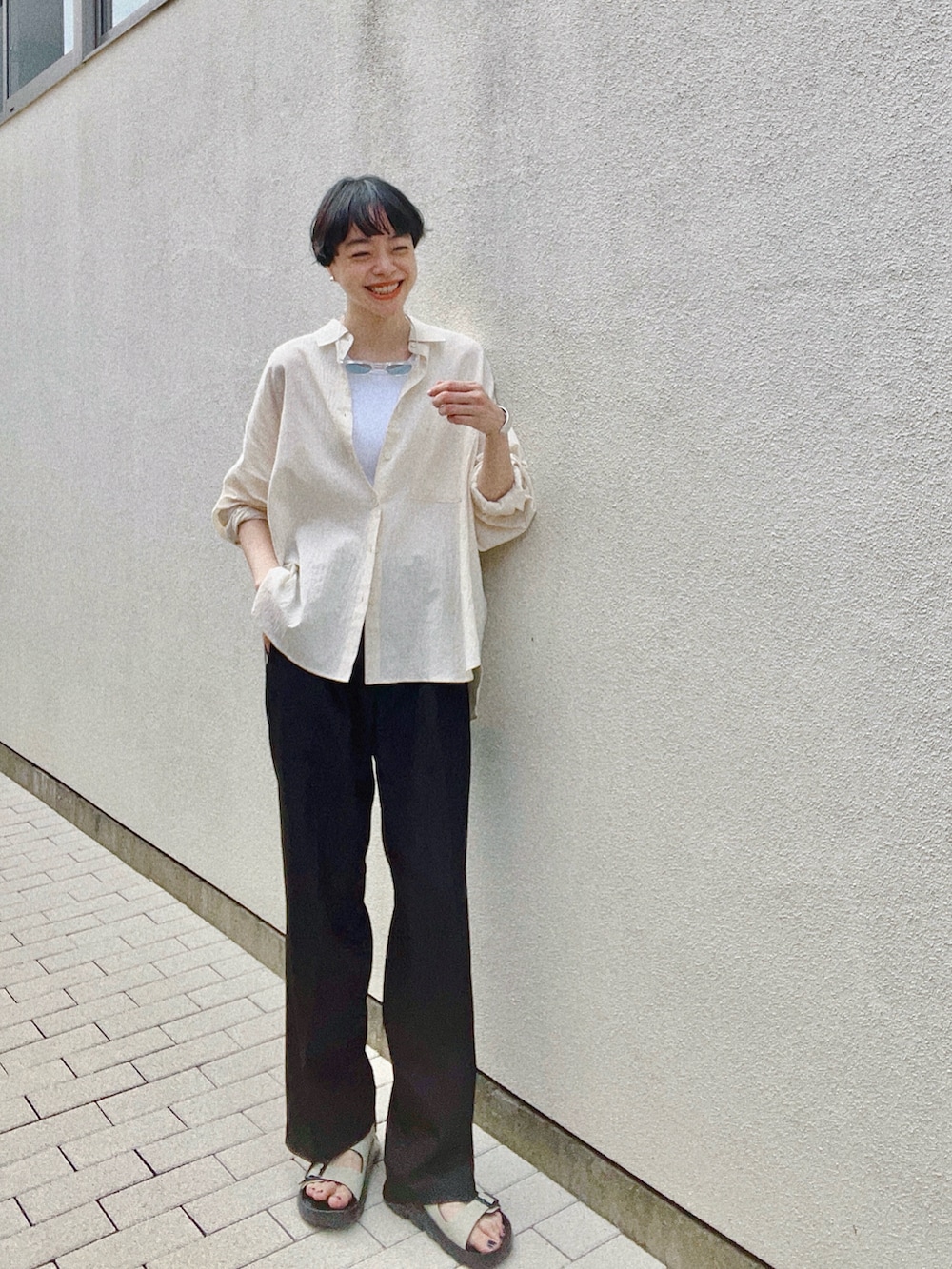 ベージュ系のシャツ/ブラウス、ホワイト系のタンクトップ、ブラック系のスラックスを着用したレディースの夏コーディネートの2枚目の写真