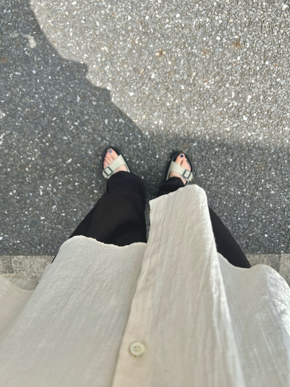 ベージュ系のシャツ/ブラウス、ホワイト系のタンクトップ、ブラック系のスラックスを着用したレディースの夏コーディネートの5枚目の写真