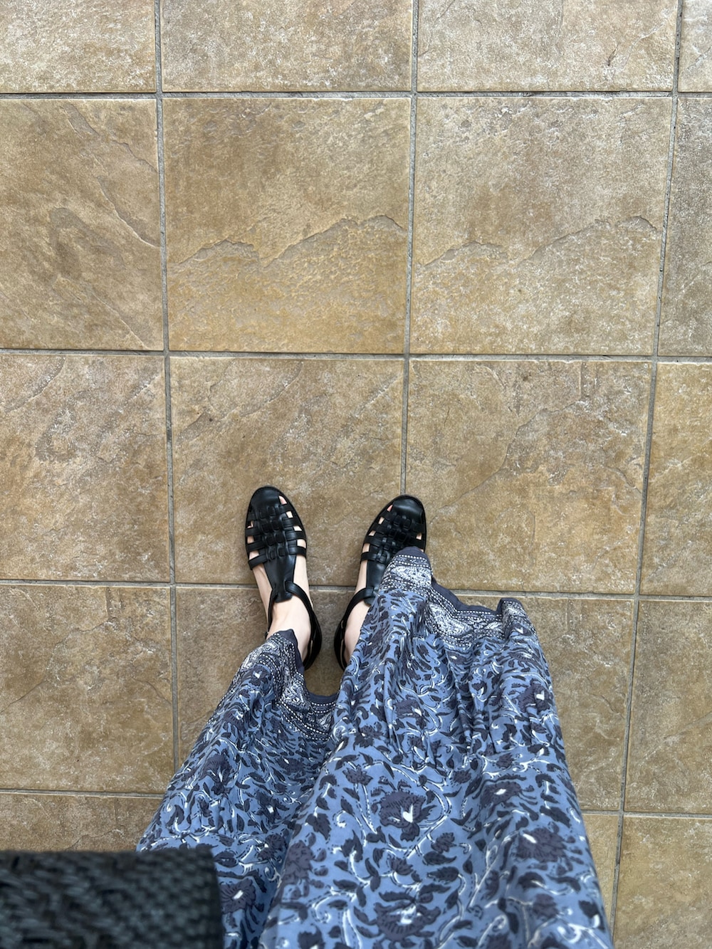 ブラック系のワンピース、ブラック系のかごバッグ、ブラック系のサンダルを着用したレディースの夏コーディネートの3枚目の写真