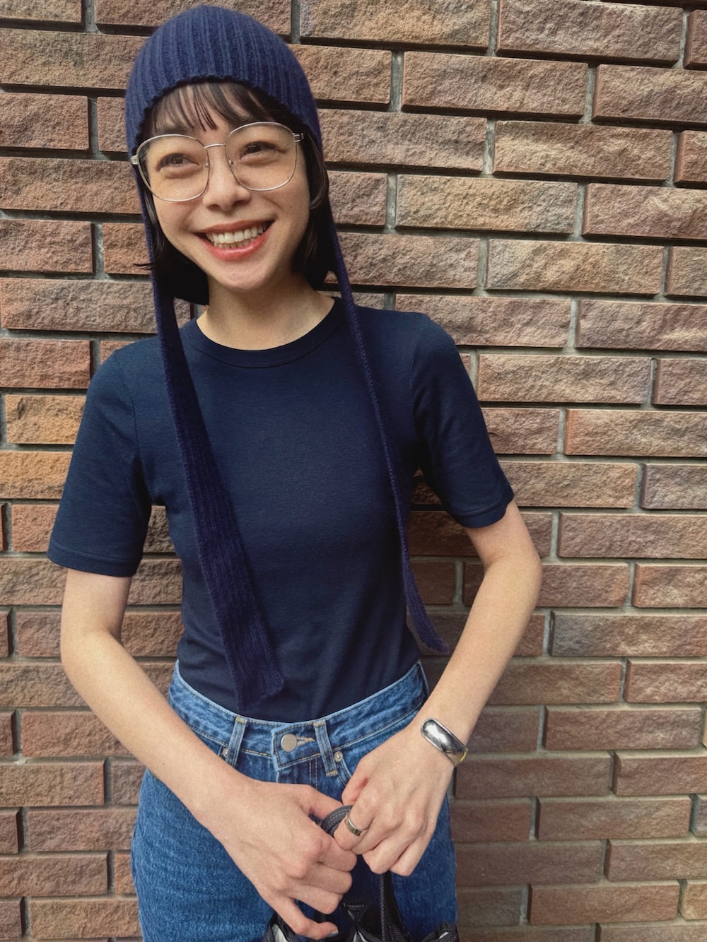 ブルー系のTシャツ/カットソー、ブラック系のバッグ、ブルー系のデニムパンツを着用したレディースの秋コーディネートの4枚目の写真