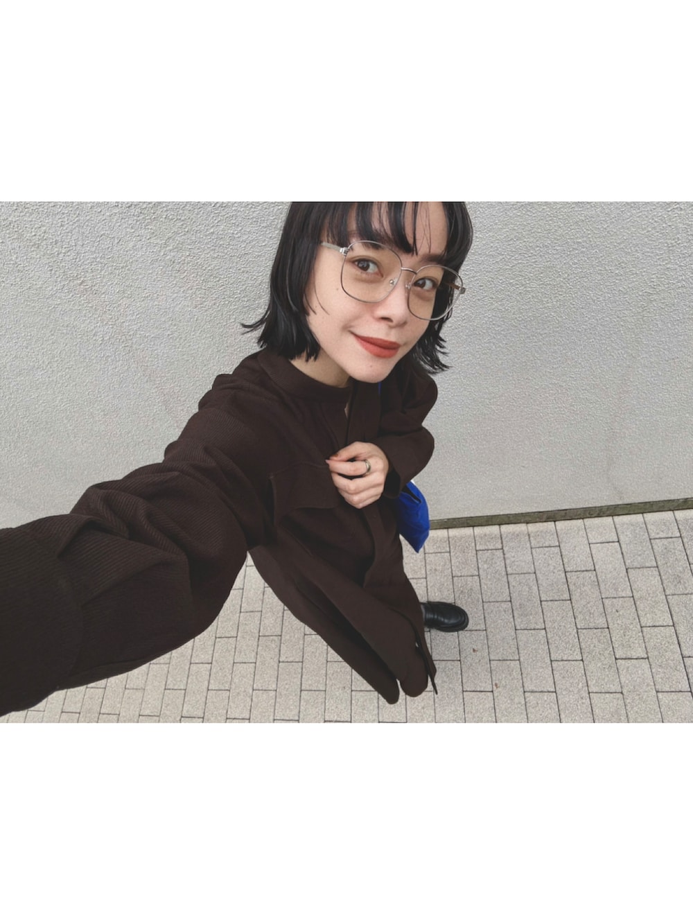 ブラウン系のワンピース、ブラック系のパンプス、ブルー系のトートバッグを着用したレディースの秋コーディネートの3枚目の写真
