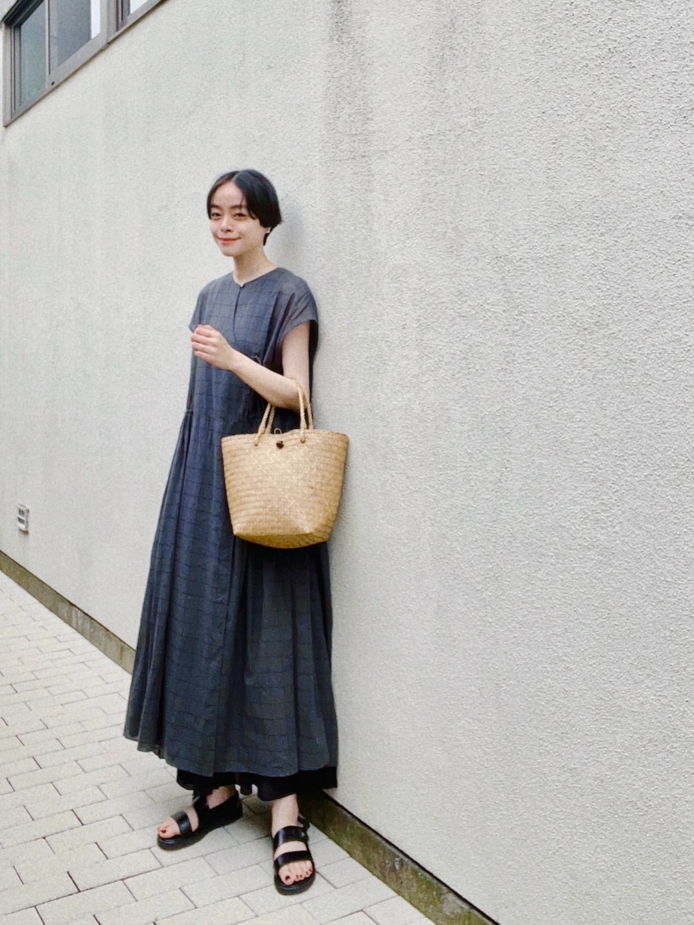 ブラック系のワンピース、ブラック系のスカート、ブラック系のサンダルを着用したレディースの春コーディネートの2枚目の写真