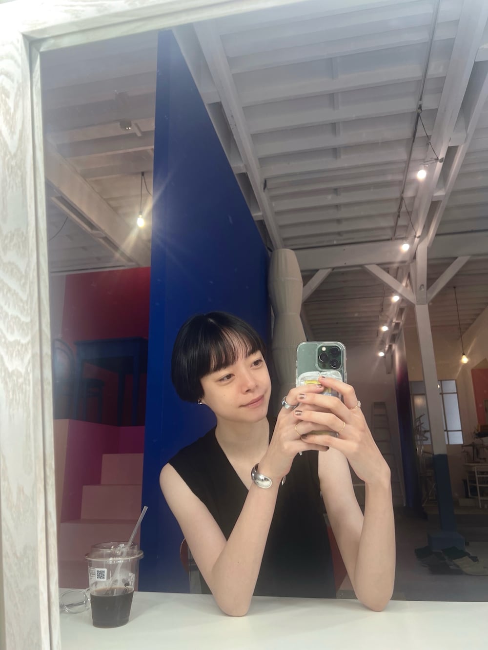 ブラック系のスニーカー、ブラック系のスカート、ブラック系のバッグを着用したレディースの秋コーディネートの5枚目の写真