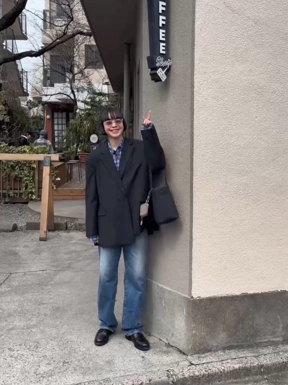 ブルー系のデニムパンツ、ブラック系のテーラードジャケット、ブルー系のシャツ/ブラウスを着用したレディースの春コーディネートの2枚目の写真