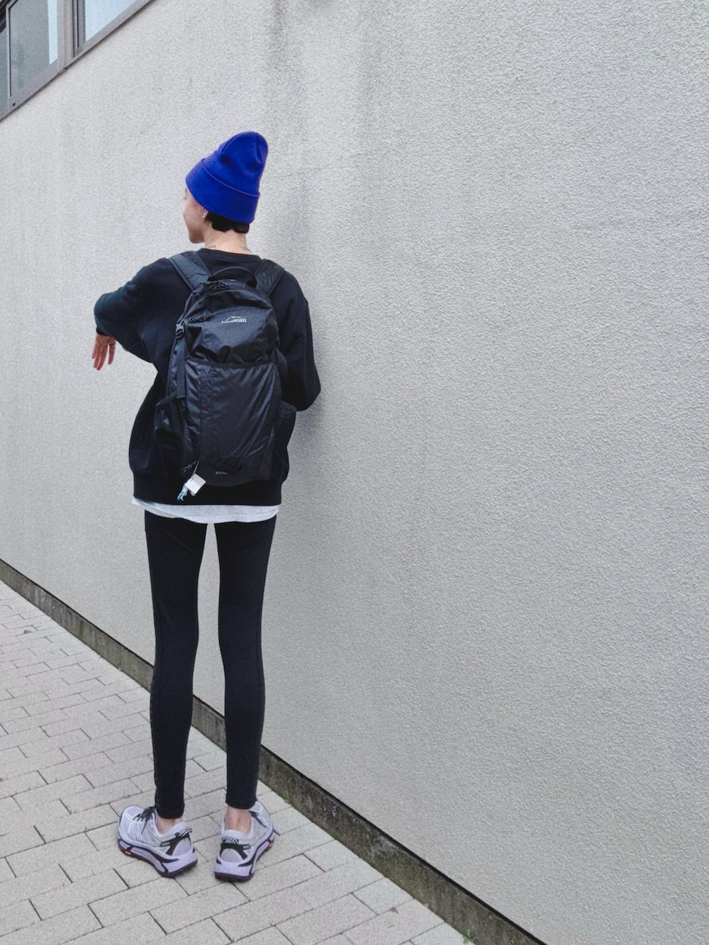 パープル系のスニーカー、ブラック系のスニーカー、ブラック系のバックパック/リュックを着用したレディースの春コーディネートの2枚目の写真