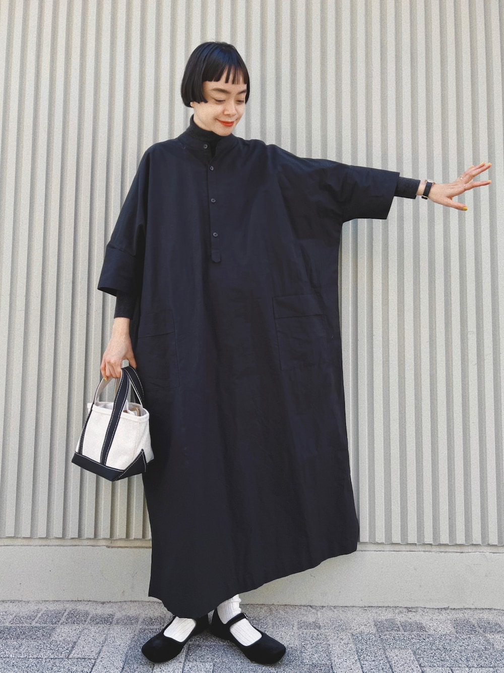ブラック系のワンピース/ドレス、ブラック系のトートバッグ、ブラック系のバレエシューズを着用したレディースの冬コーディネートの3枚目の写真