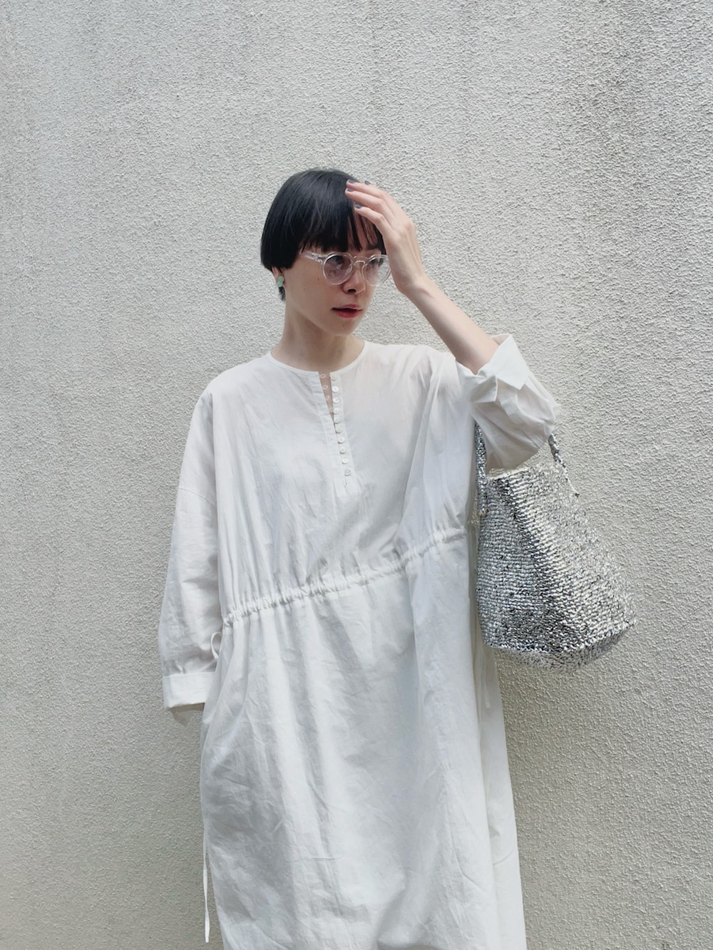 シルバー系のバッグ、ホワイト系のサンダル、ホワイト系のワンピース/ドレスを着用したレディースの夏コーディネートの3枚目の写真