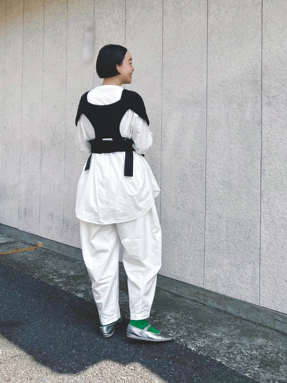 ホワイト系のシャツ/ブラウス、ホワイト系のパンツ、グレー系のシューズを着用したレディースの春コーディネートの2枚目の写真