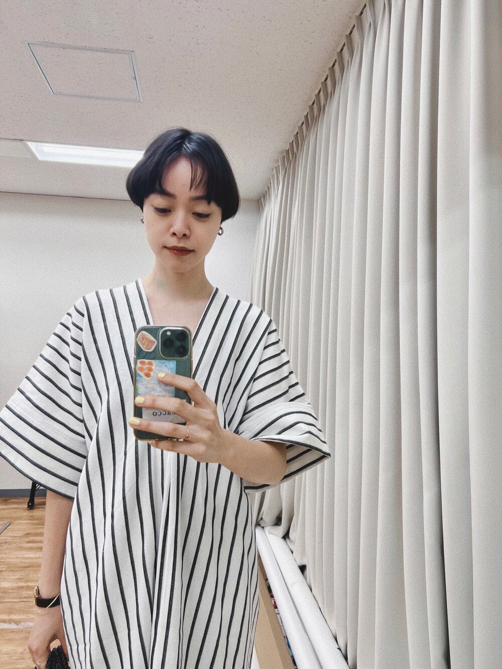 ホワイト系のワンピース、ブラック系のかごバッグ、ブラック系のサンダルを着用したレディースの夏コーディネートの2枚目の写真