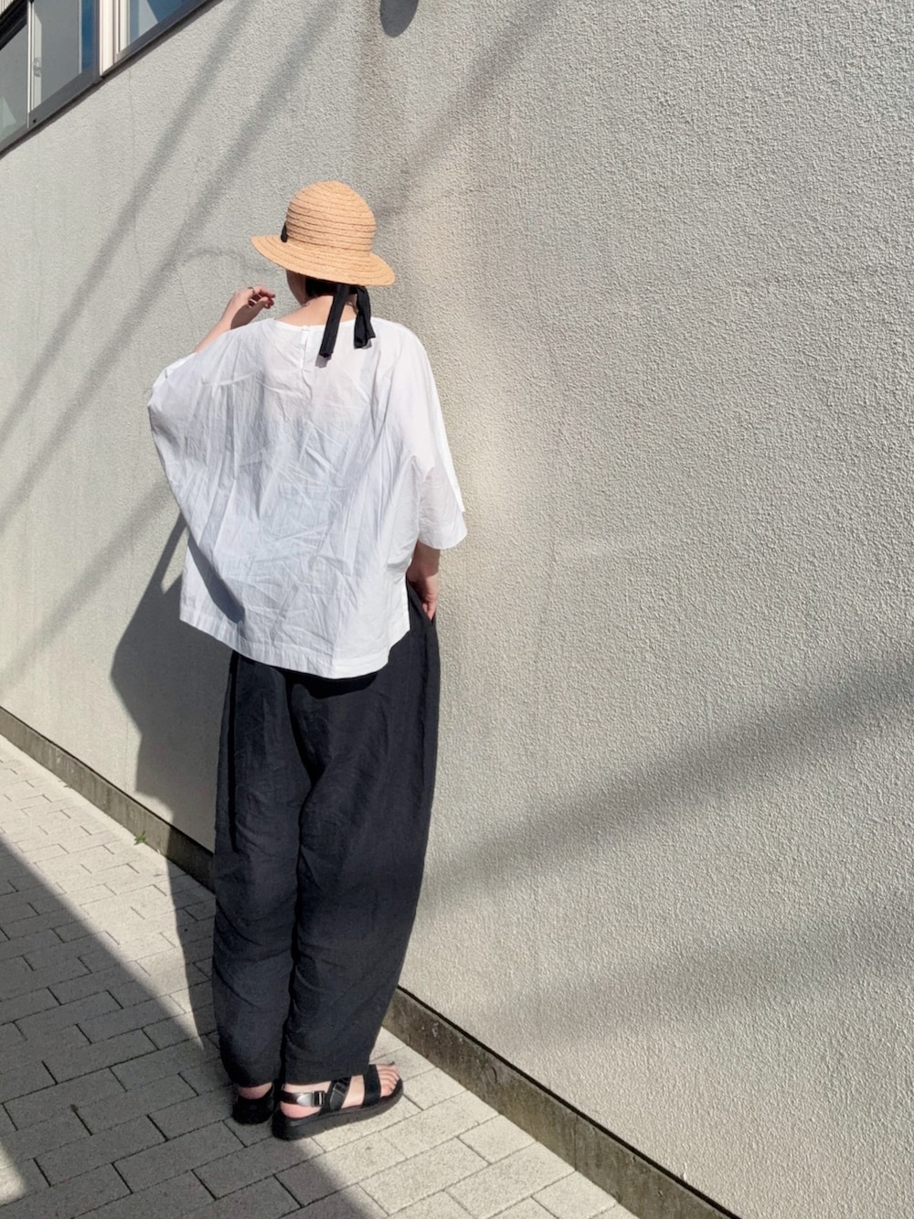 ホワイト系のシャツ/ブラウス、ブラック系のパンツ、ブラック系のサンダルを着用したレディースの夏コーディネートの2枚目の写真
