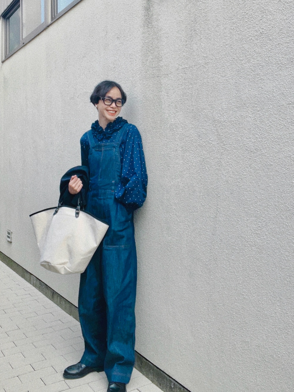 ホワイト系のバッグ、ブルー系のオールインワン・サロペット、ブラック系のドレスシューズを着用したレディースの春コーディネートの2枚目の写真