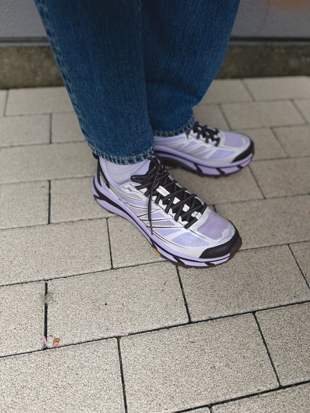 ブラック系のテーラードジャケット、ブラック系のバックパック/リュック、ブルー系のデニムパンツを着用したレディースの春コーディネートの3枚目の写真