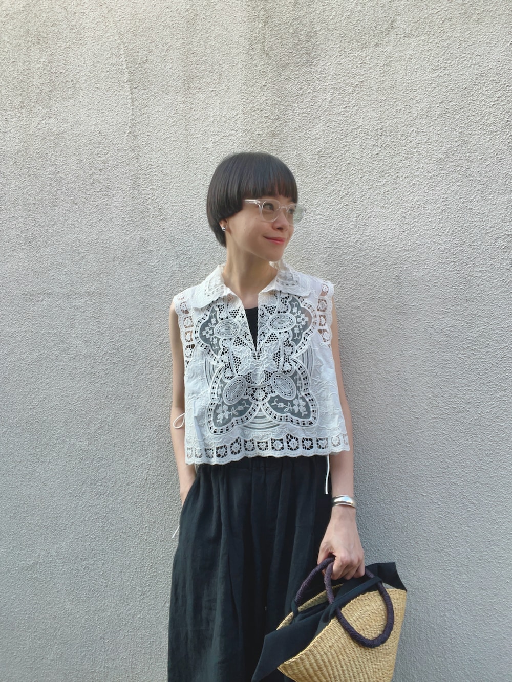 ブラック系のサンダル、ブラック系のかごバッグ、ホワイト系のシャツ/ブラウスを着用したレディースの夏コーディネートの2枚目の写真