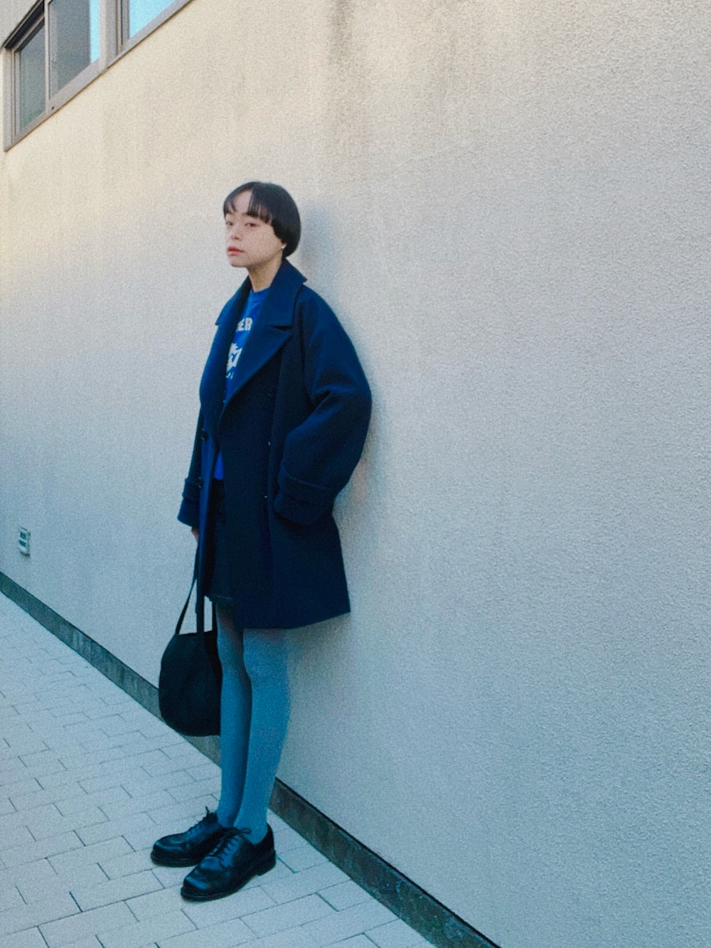 ブラック系のドレスシューズ、ブルー系のデニムスカート、ブルー系のその他アウターを着用したレディースの冬コーディネートの2枚目の写真