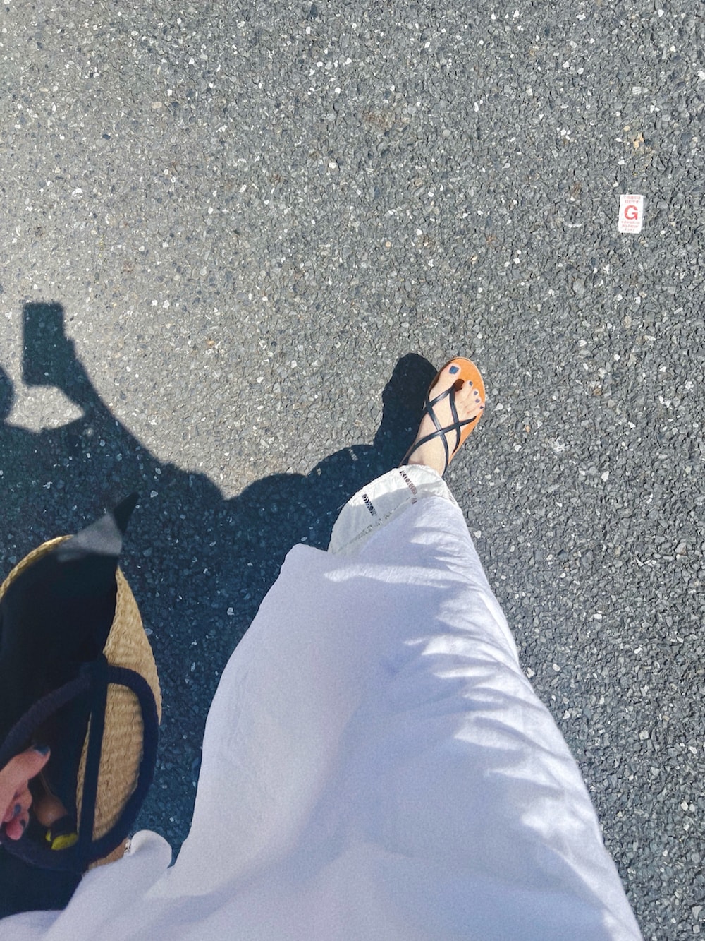 ホワイト系のワンピース、ブラック系のかごバッグ、ホワイト系のその他パンツを着用したレディースの夏コーディネートの4枚目の写真