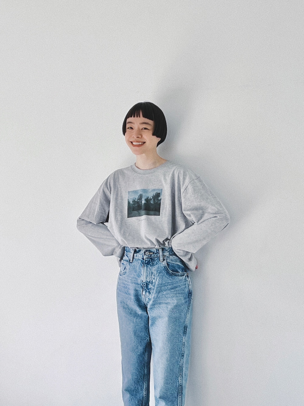 グレー系のTシャツ/カットソー、ブルー系のデニムパンツ、ホワイト系のローファーを着用したレディースの春コーディネートの2枚目の写真