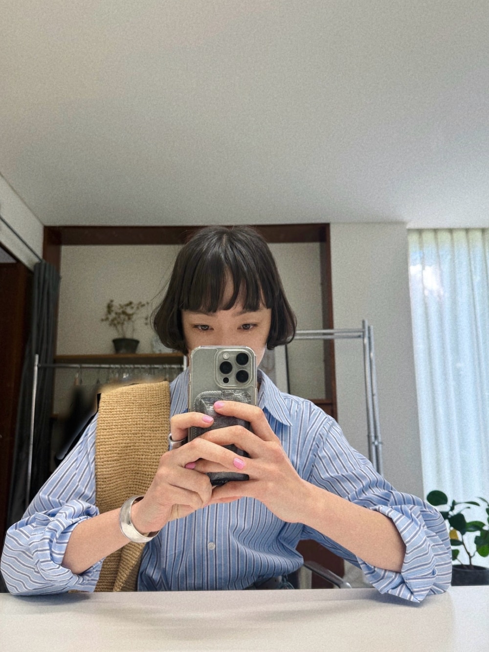 ブルー系のデニムパンツ、ブルー系のシャツ/ブラウス、ベージュ系のショルダーバッグを着用したレディースの春コーディネートの2枚目の写真