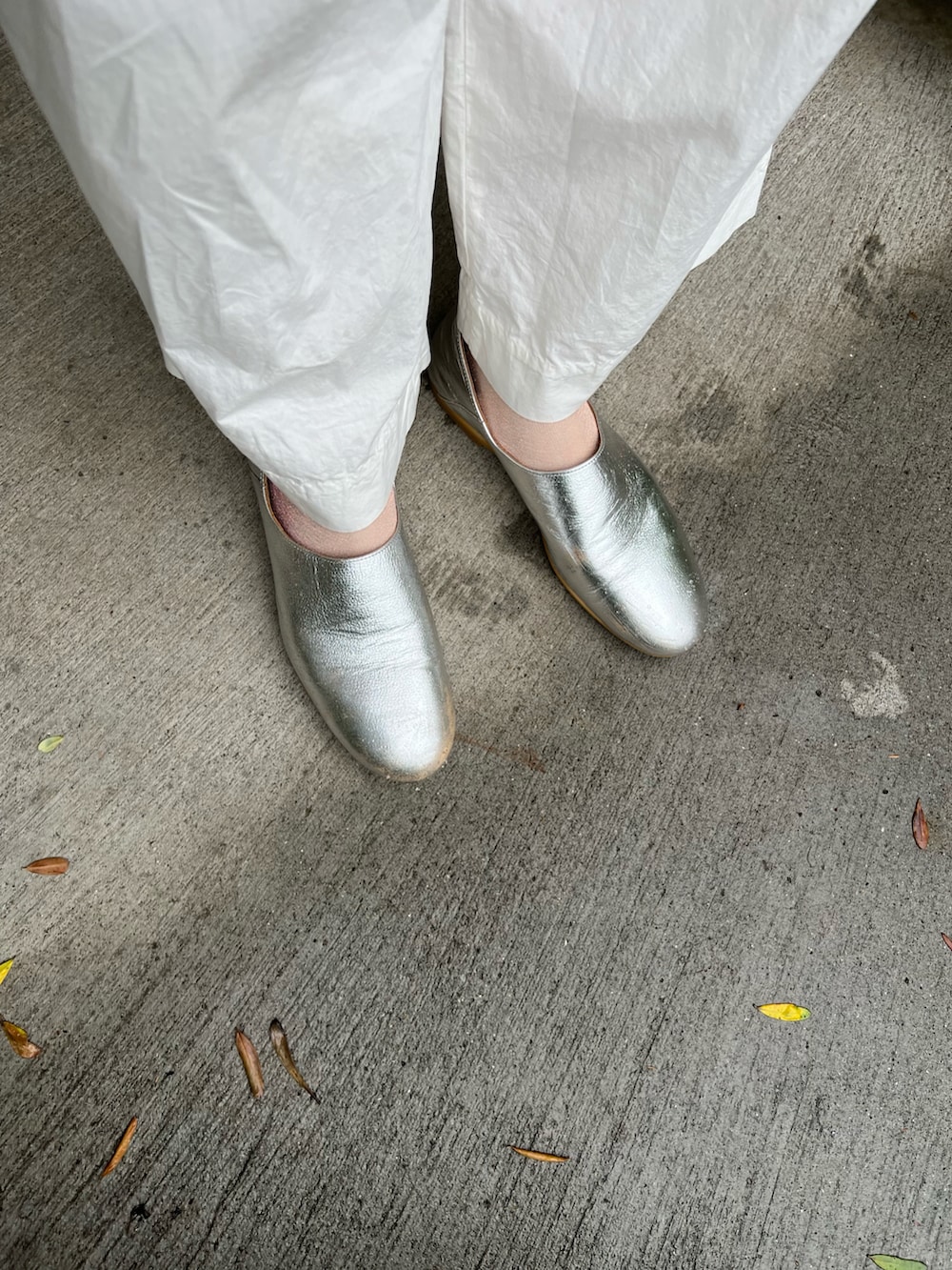 ピンク系のカーディガン/ボレロ、ホワイト系のかごバッグ、シルバー系のスリッポンを着用したレディースの夏コーディネートの2枚目の写真