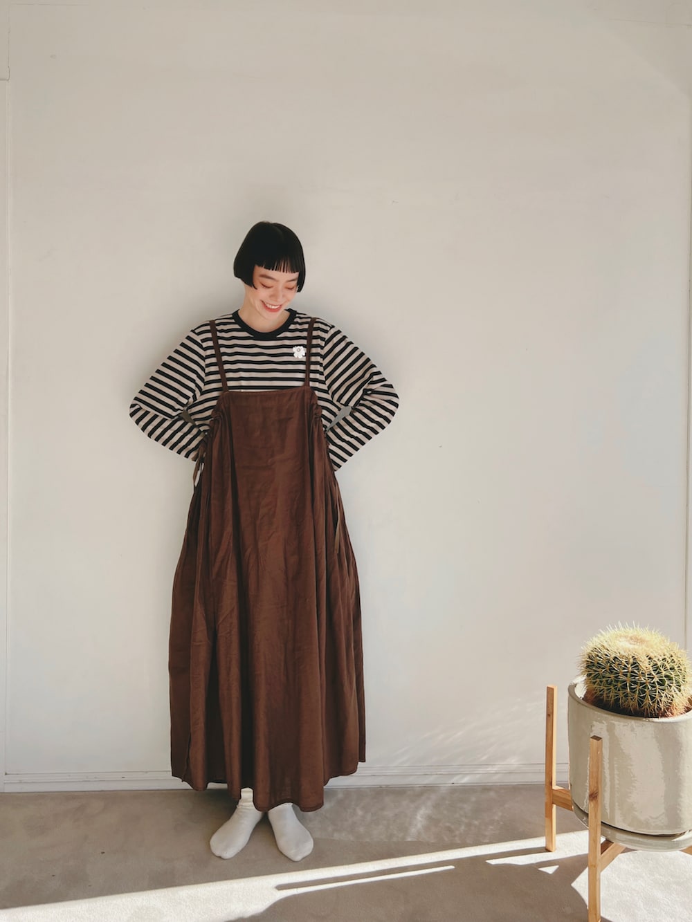 ベージュ系のTシャツ/カットソー、ブラウン系のワンピース/ドレス、ブラック系のバレエシューズを着用したレディースの冬コーディネートの2枚目の写真