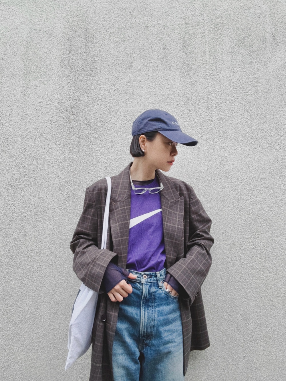 ブラウン系のテーラードジャケット、ブルー系のデニムパンツ、ブラウン系のローファーを着用したレディースの春コーディネートの3枚目の写真