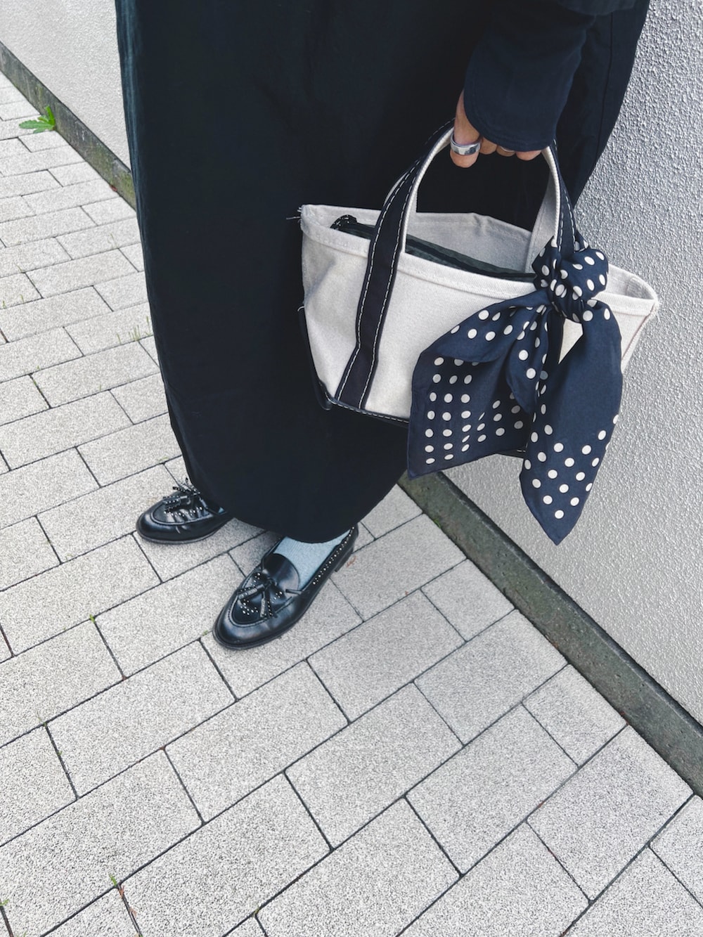 ブラック系のワンピース/ドレス、ブラック系のローファー、ブラック系のトートバッグを着用したレディースの秋コーディネートの4枚目の写真
