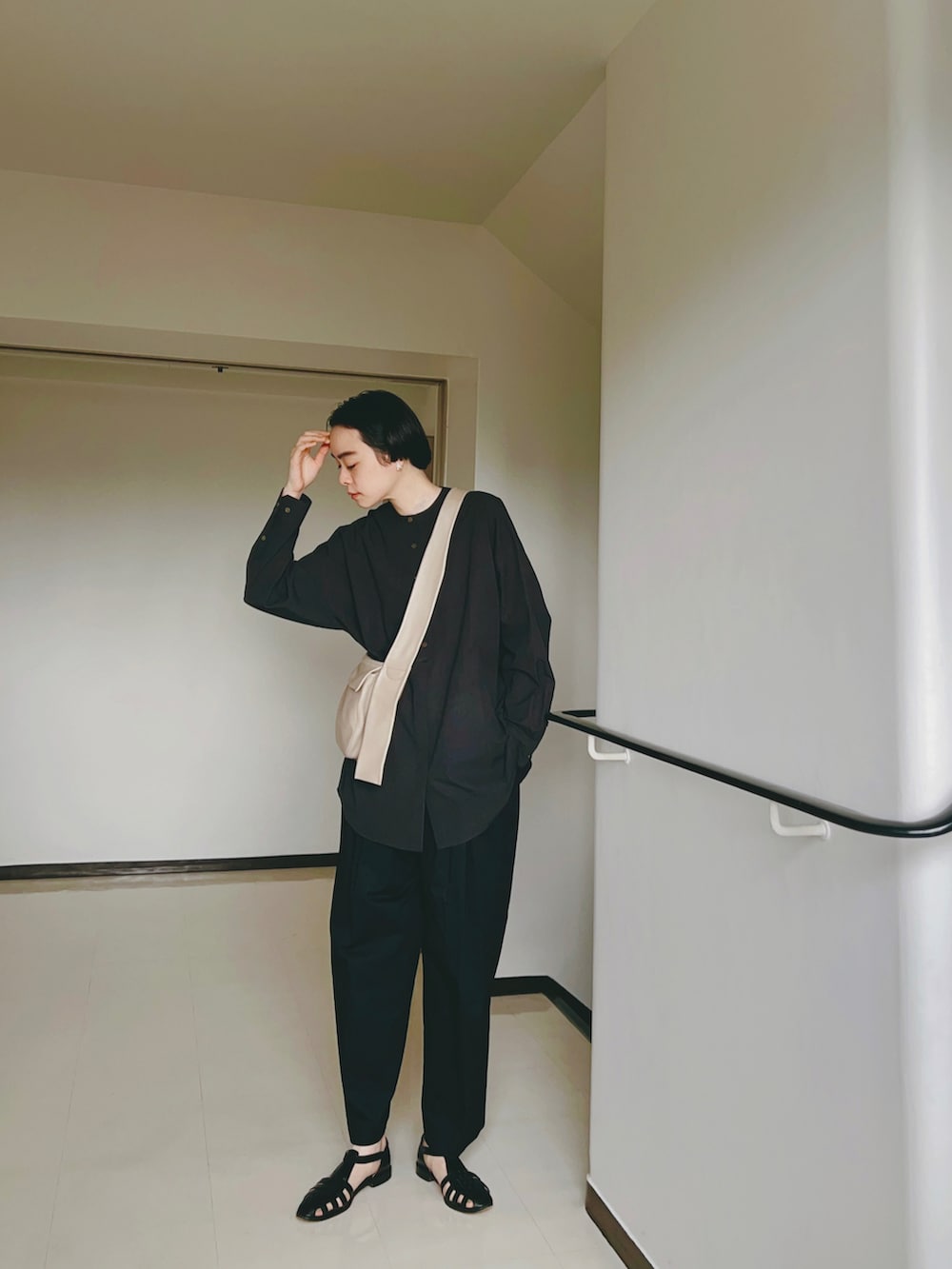 ブラック系のシャツ/ブラウス、ベージュ系のバッグ、ブラック系のその他パンツを着用したレディースの春コーディネートの2枚目の写真