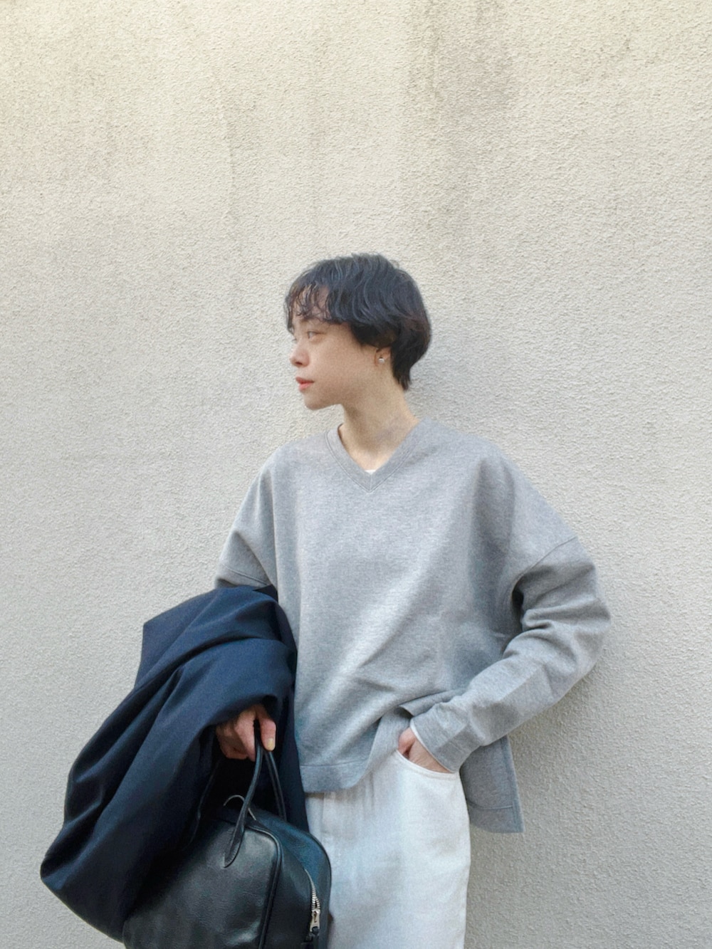 グレー系のスウェット、ホワイト系のデニムパンツ、ブラック系のシューズを着用したレディースの春コーディネートの3枚目の写真