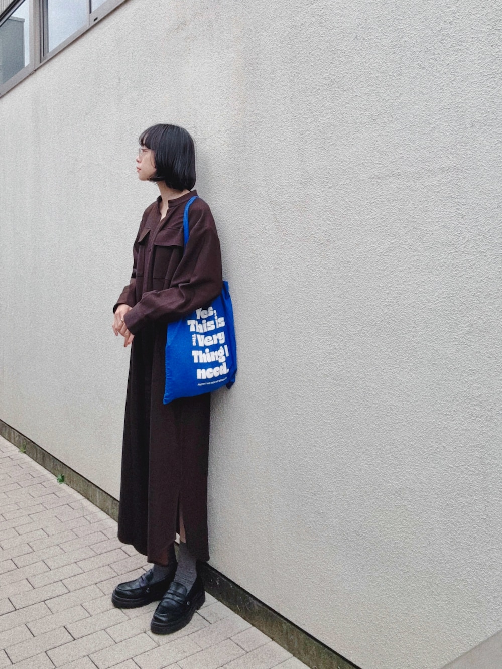 ブラウン系のワンピース、ブラック系のパンプス、ブルー系のトートバッグを着用したレディースの秋コーディネートの2枚目の写真