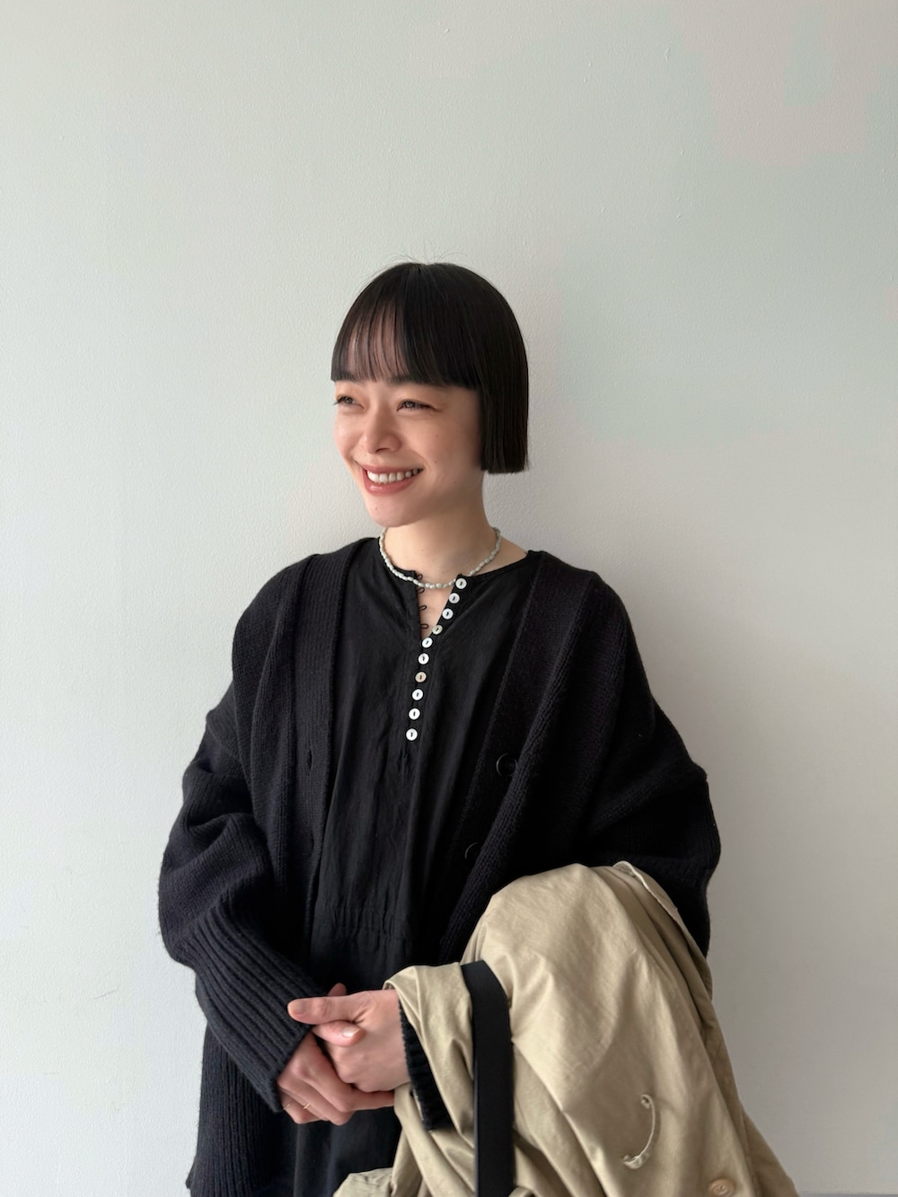 ベージュ系のトレンチコート、ブラック系のワンピース/ドレス、ブラック系のカーディガン/ボレロを着用したレディースの春コーディネートの5枚目の写真