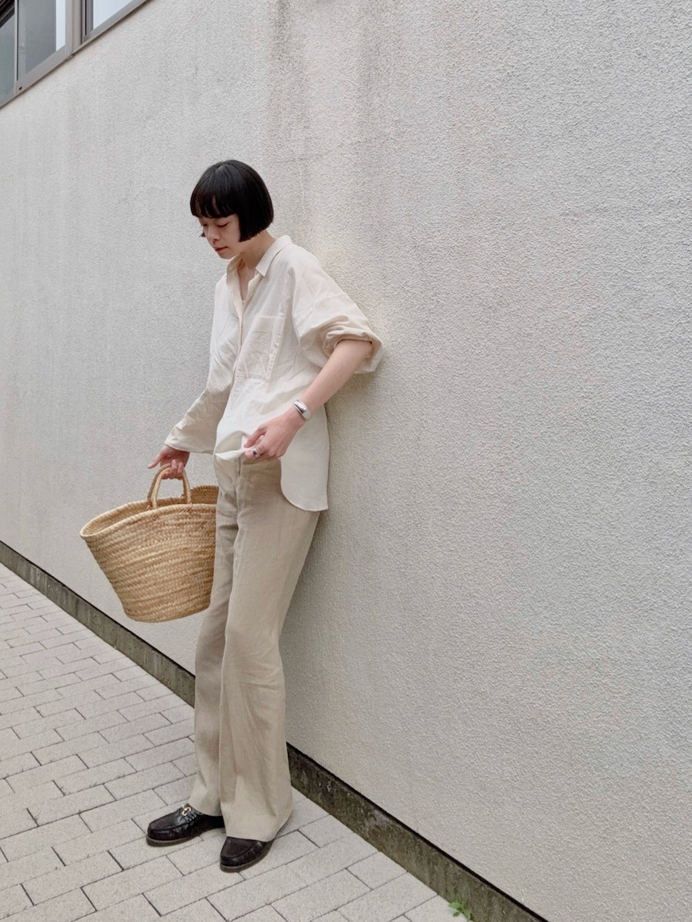 ベージュ系のかごバッグ、ベージュ系のシャツ/ブラウス、ベージュ系のパンツを着用したレディースの春コーディネートの2枚目の写真