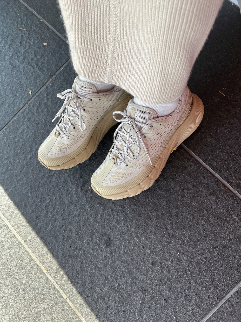 ベージュ系のジャケット/アウター、ベージュ系のワンピース、ベージュ系のかごバッグを着用したレディースの冬コーディネートの2枚目の写真