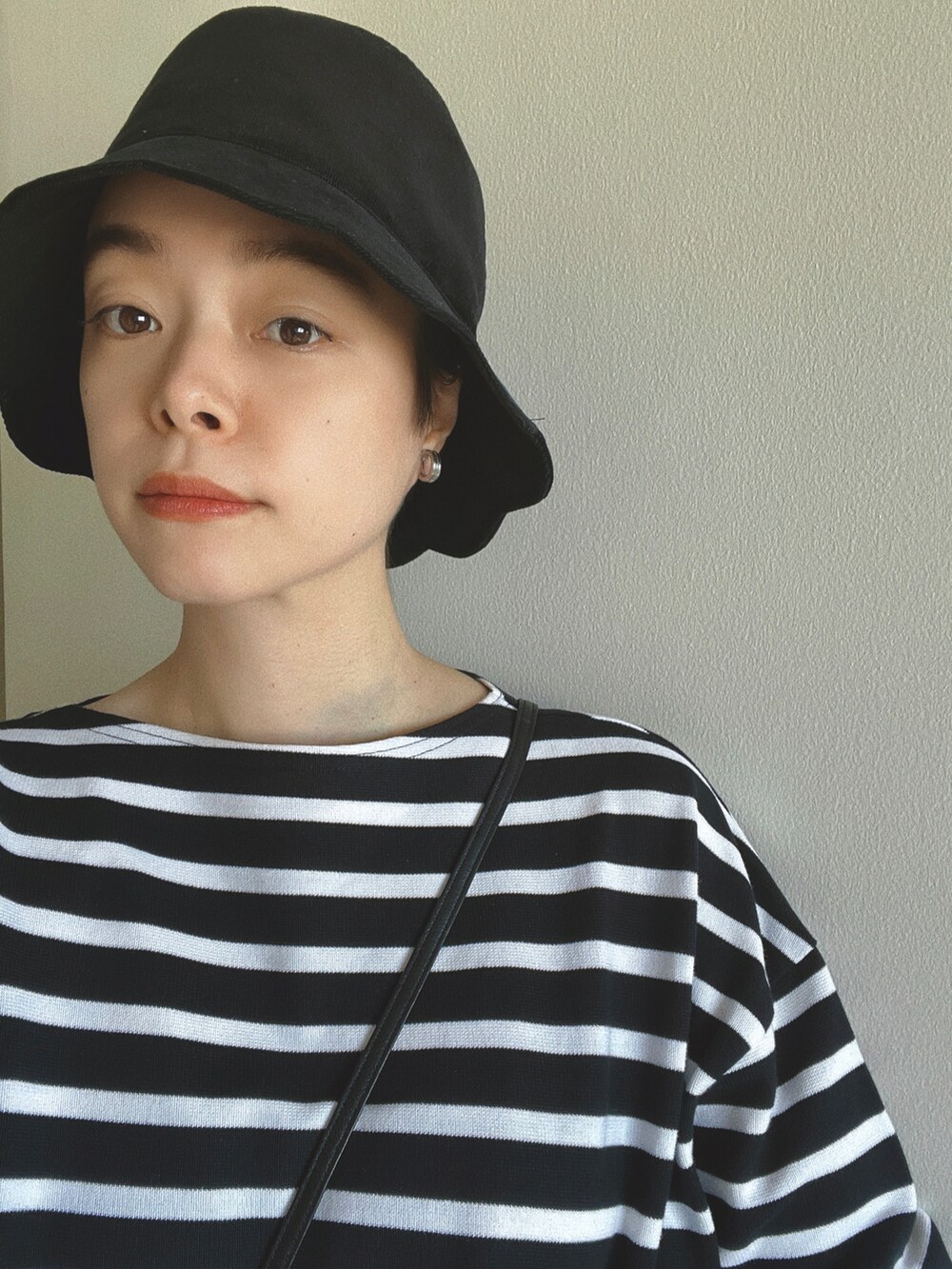 ブラック系のトップス、ブラック系のバレエシューズ、ブラック系の帽子を着用したレディースの秋コーディネートの2枚目の写真