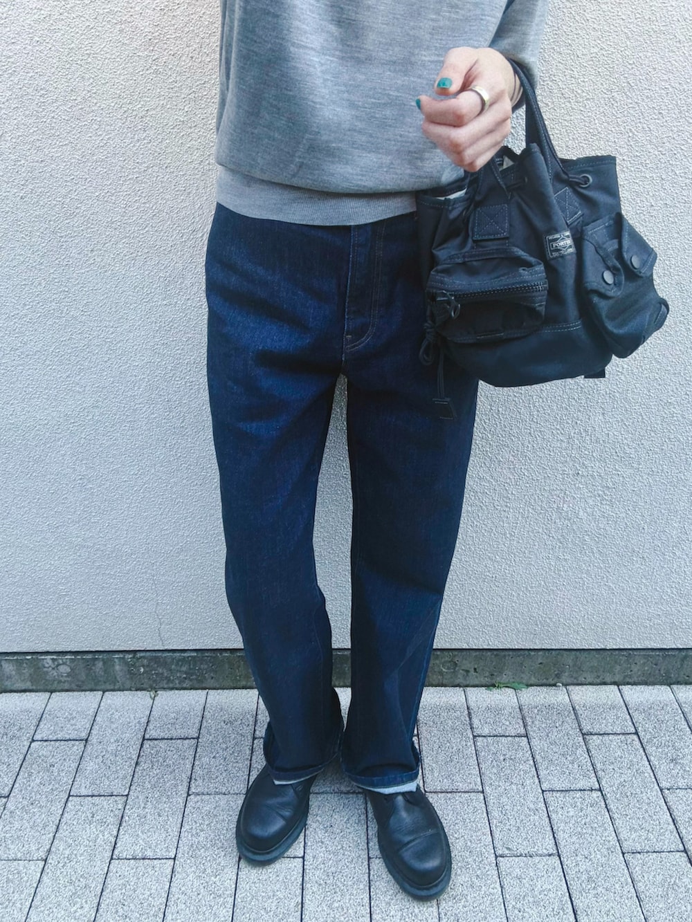 ブラック系のシューズ、ブルー系のデニムパンツ、グレー系のニット/セーターを着用したレディースの秋コーディネートの4枚目の写真