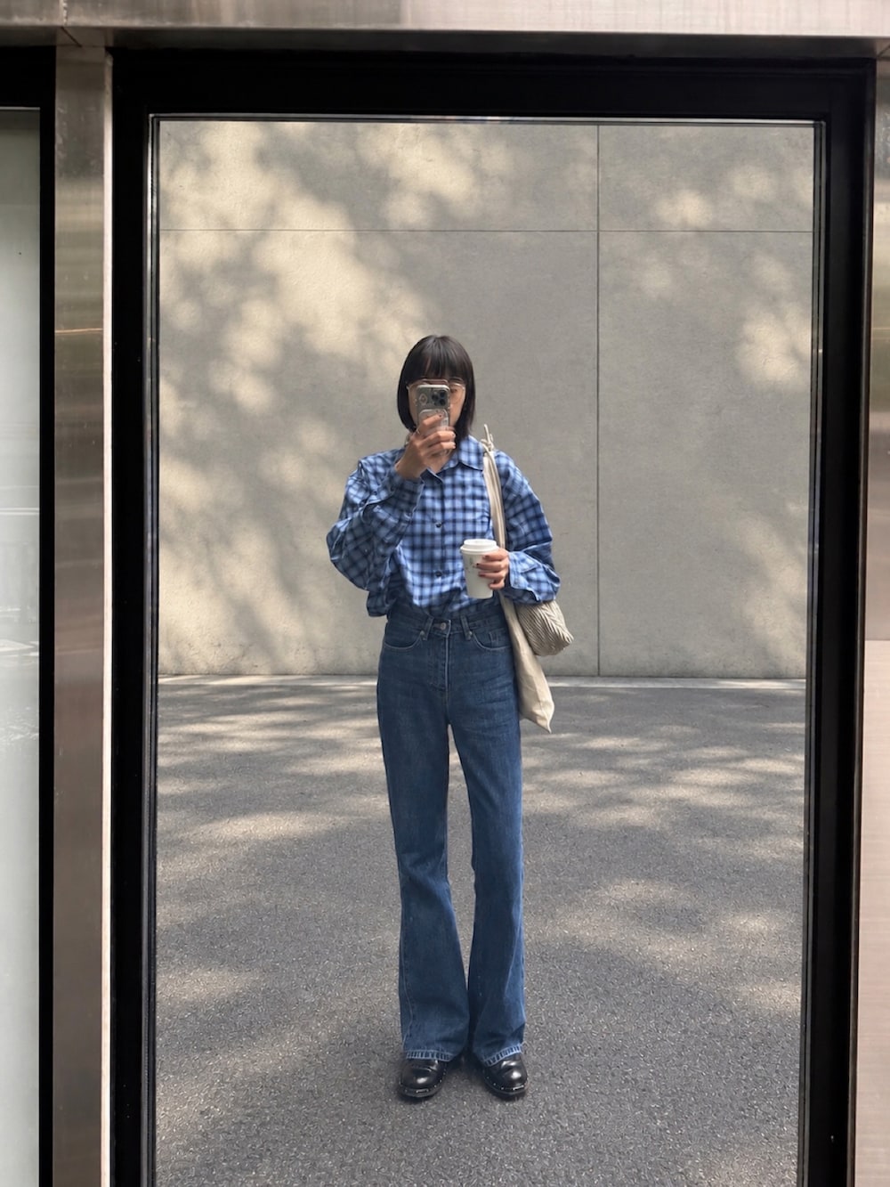ブルー系のデニムパンツ、ブラック系のその他シューズ、ブルー系のシャツ/ブラウスを着用したレディースの秋コーディネートの3枚目の写真