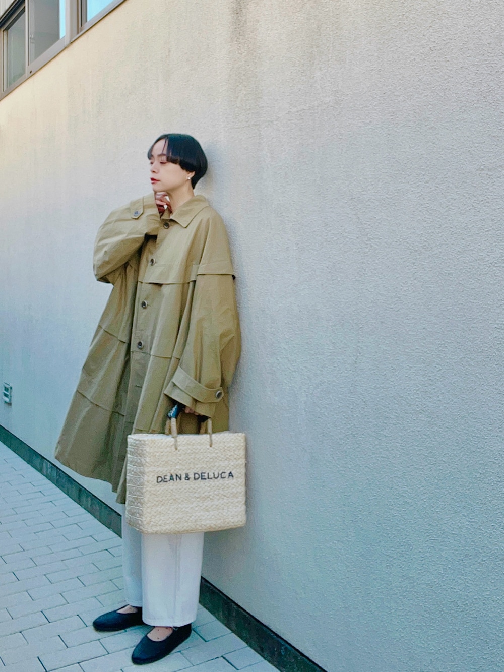 ホワイト系のデニムパンツ、ベージュ系のかごバッグ、ブラック系のシューズを着用したレディースの春コーディネートの2枚目の写真