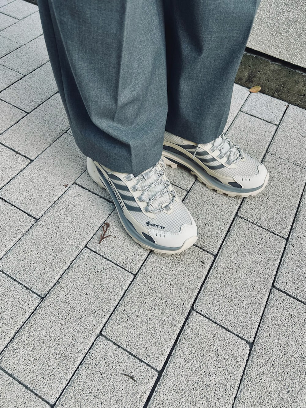 ブラック系のシャツ/ブラウス、グレー系のスラックス、ホワイト系のスニーカーを着用したレディースの秋コーディネートの2枚目の写真