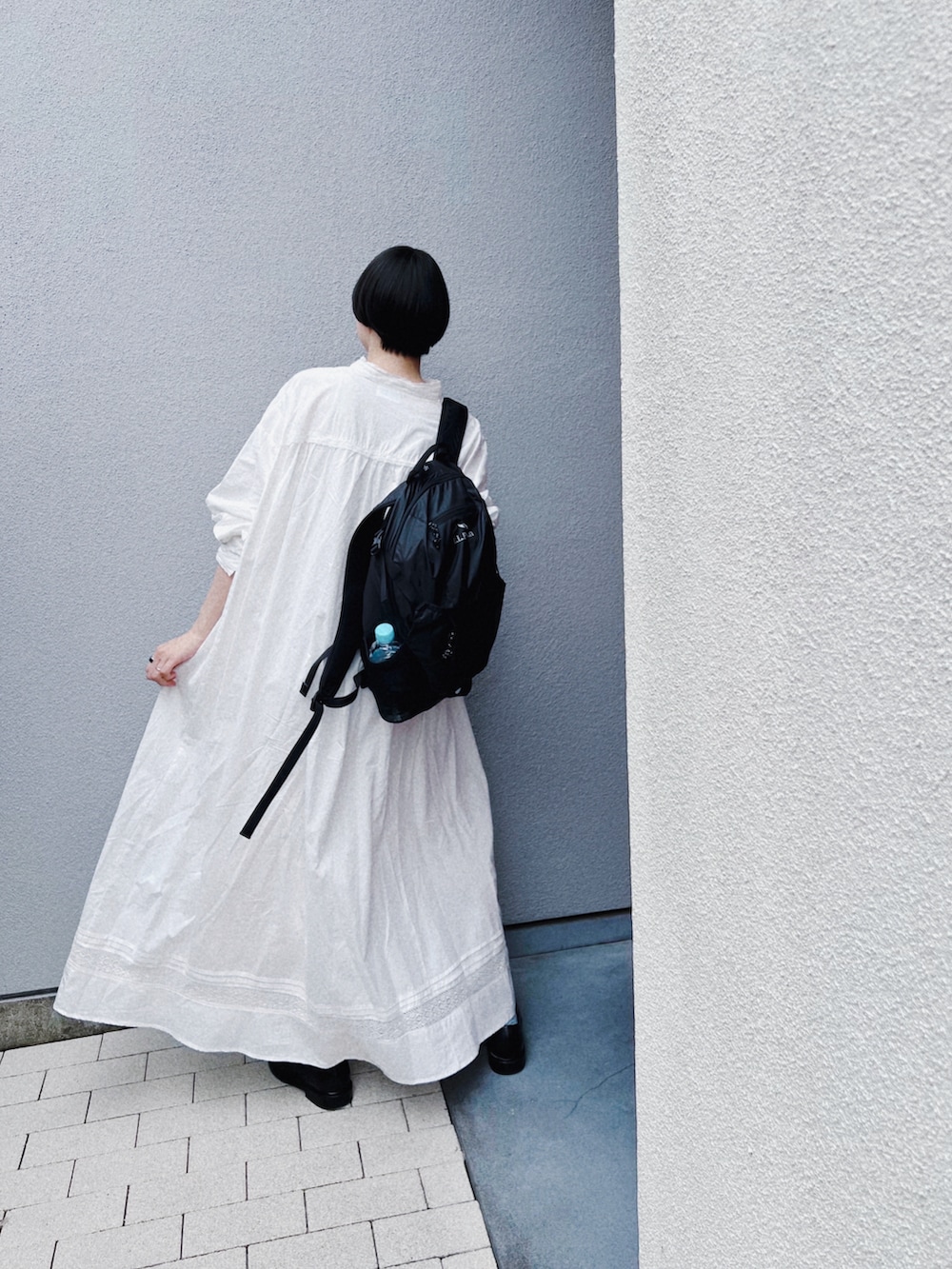 ホワイト系のワンピース、ブラック系のバックパック/リュック、ブラック系のドレスシューズを着用したレディースの秋コーディネートの2枚目の写真