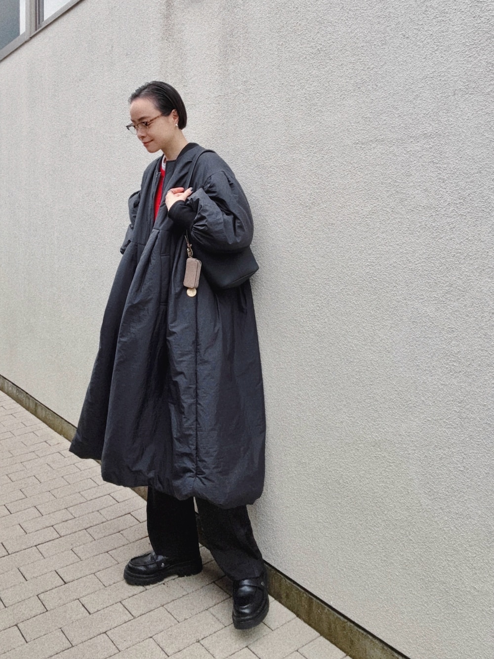 レッド系のカーディガン/ボレロ、ホワイト系のTシャツ/カットソー、ブラック系のバッグを着用したレディースの冬コーディネートの3枚目の写真