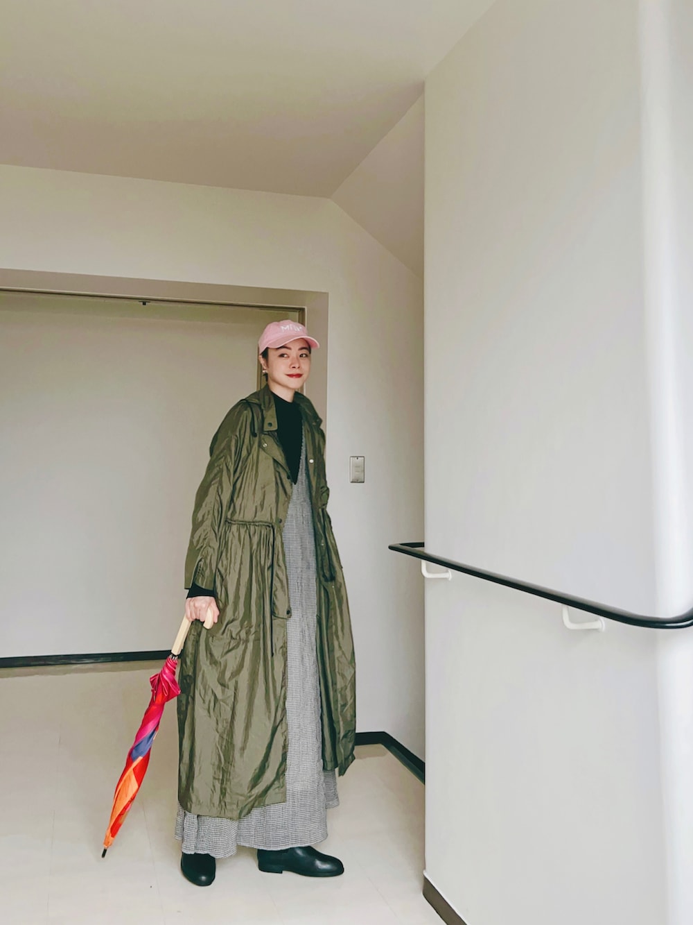 ピンク系のトートバッグ、ホワイト系のワンピース、ブラック系のブーツを着用したレディースの春コーディネートの2枚目の写真