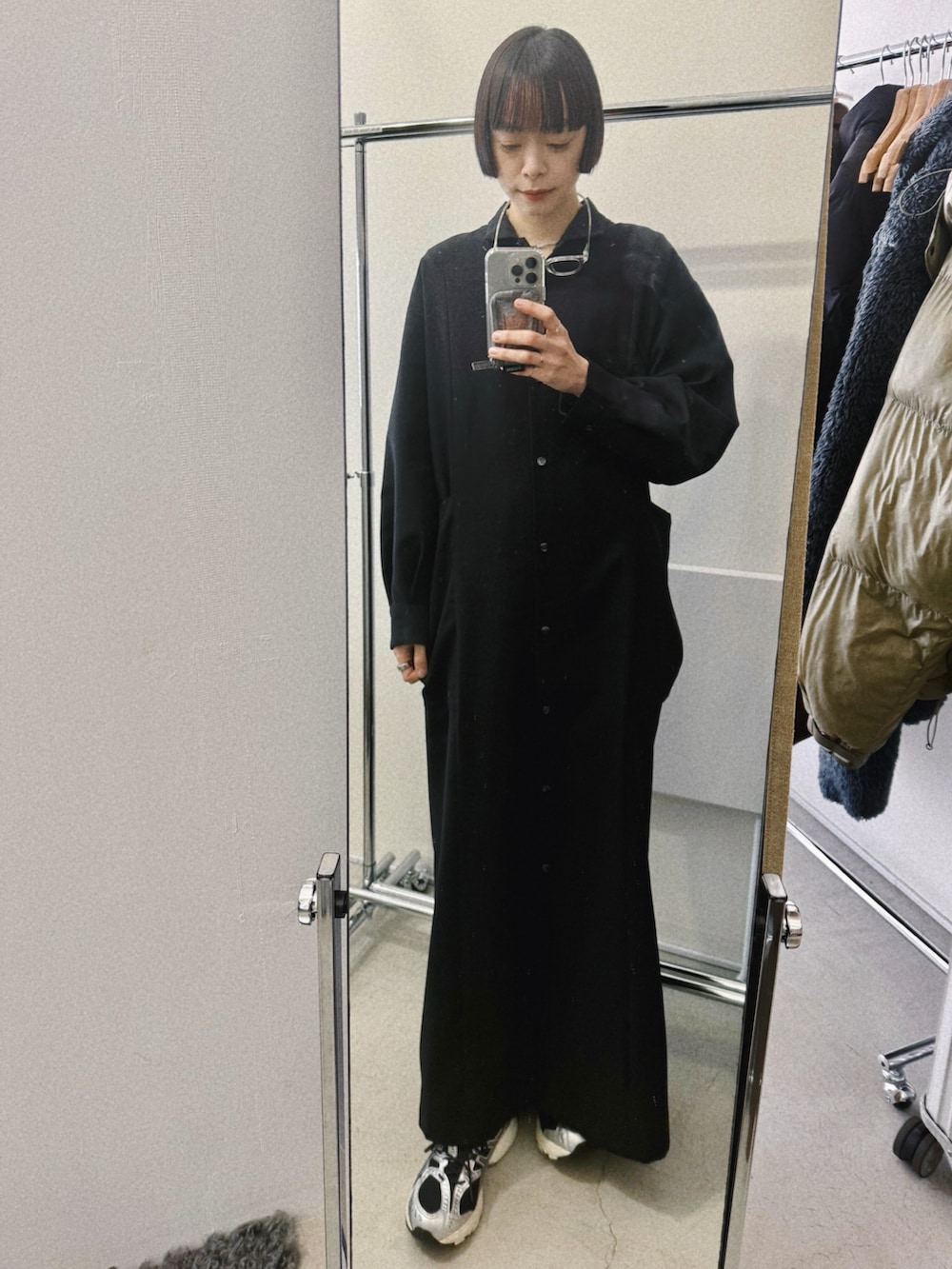 ブラック系のバックパック/リュック、ブラック系のドレス、ブラック系のスニーカーを着用したレディースの冬コーディネートの3枚目の写真