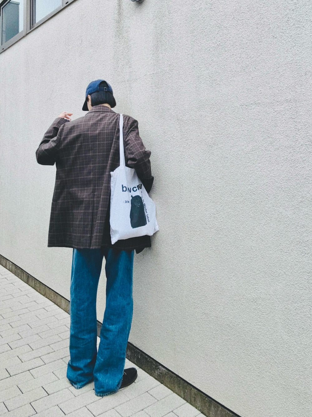 ブラウン系のテーラードジャケット、ブルー系のデニムパンツ、ブラウン系のローファーを着用したレディースの春コーディネートの2枚目の写真