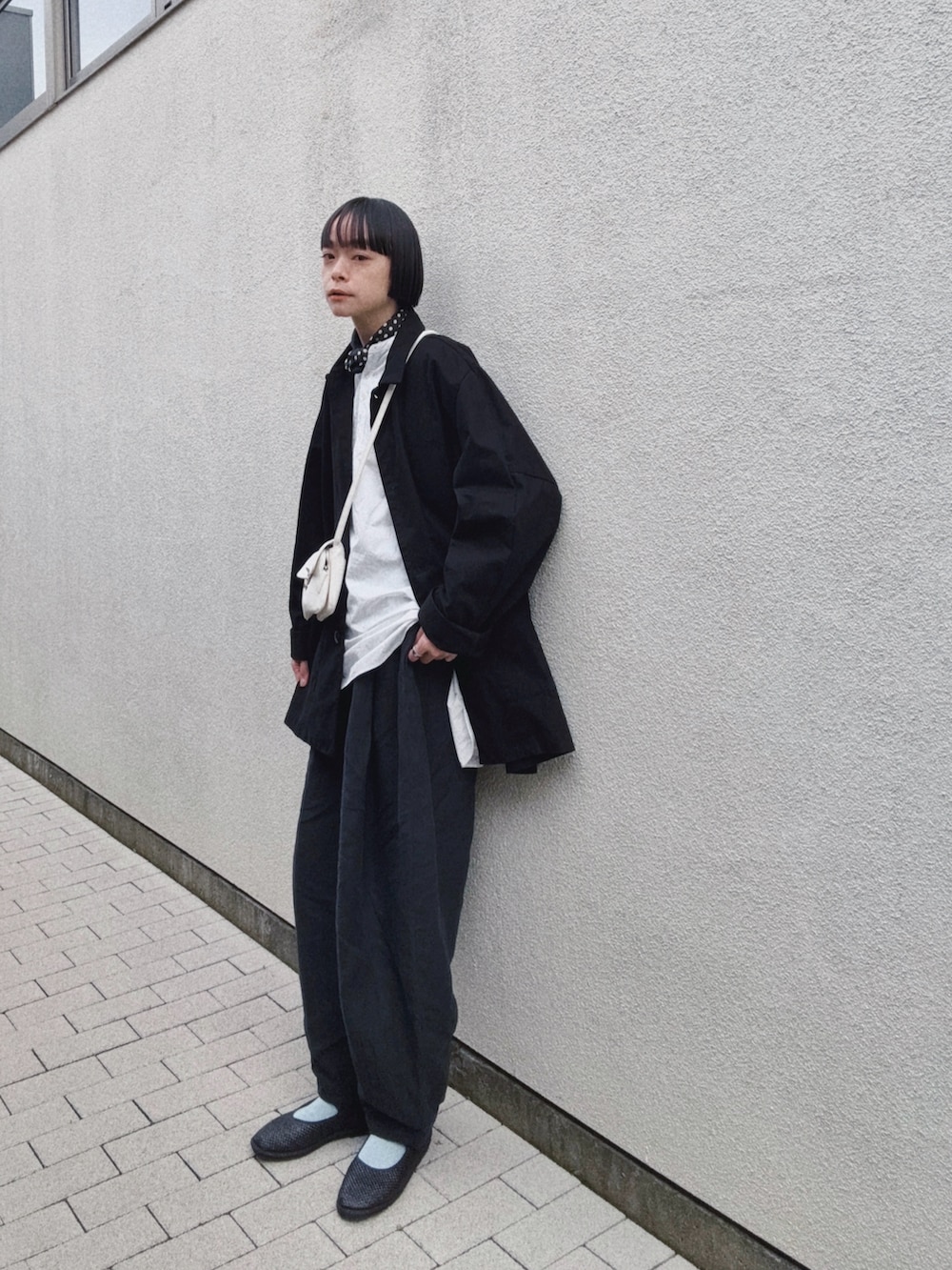 ブラック系のジャケット/アウター、ホワイト系のバッグ、ブラック系のパンツを着用したレディースの春コーディネートの2枚目の写真