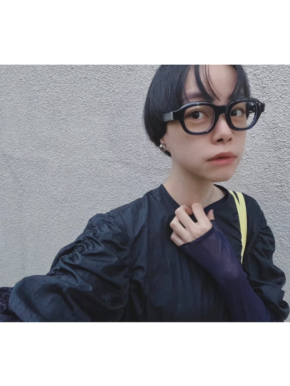 イエロー系のトートバッグ、ブルー系のスニーカー、ブラック系のワンピースを着用したレディースの秋コーディネートの2枚目の写真